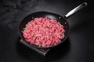 Fresh raw beef mince with onions in a pan photo