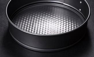 Round cake pan, tray or mould on a black concrete background photo