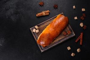 Delicious fresh roll with apricot jam on a dark concrete background photo