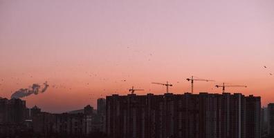 grúa de construcción que construye una casa a la hora del amanecer temprano en la mañana. Kiev, Ucrania foto