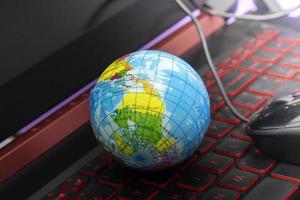 Small globe Placed on a laptop computer. photo