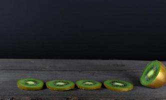 Kiwi fruit on wooden background with copy space photo