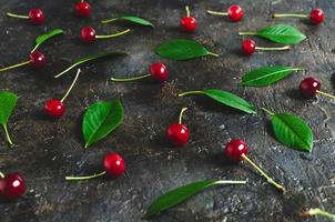 Cherry berries with leaves on the old, rustic concrete floor.
