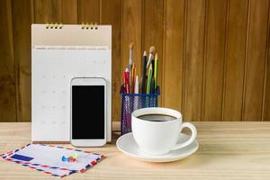 office supplies and coffee on wooden table photo