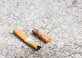 Cigarette butt discarded on the cement floor photo