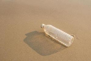 botellas de plástico en la arena de la playa foto