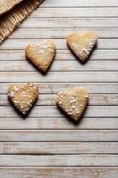 Delicious home-made heart-shaped cookies sprinkled with icing sugar in a wooden board. Horizontal image seen from above. photo