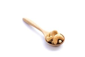 Cashews in the wooden spoon on white background