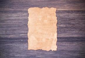 Old paper on dark wooden table background. photo