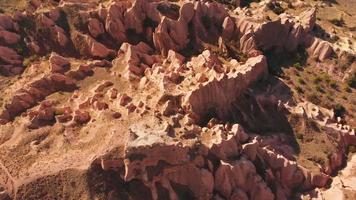 vista aerea dall'alto in basso cappadocia rocce rosse e valli di rose, goreme turchia video