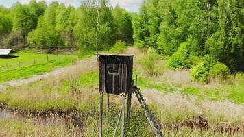 Aerial view hunters wooden cabin for hunting by forest in Lithuania countryside video