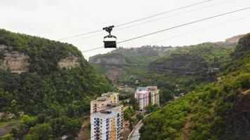 Aerial rising view ropeway with metal buckets with load above road in Mining area in Chiatura. Transporting container. Cable railway concept. Transportation and mining Industry video