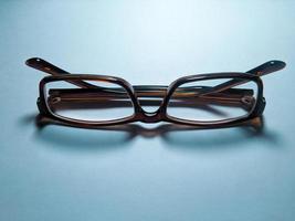 Folded glasses on blue background photo