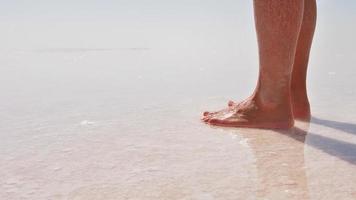 vue rapprochée statique mouvement des orteils féminins avec pieds nus sur la relaxation du lac salé. sain video