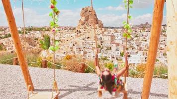 dreamy caucasian girl on famous Cappadocia swings enjoy sunset in Turkey video