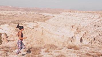 Side view outdoor workout - caucasian young female tired running on trail in scenic nature. Work hard lose weight activity concept. News years resolutions get fit concept video