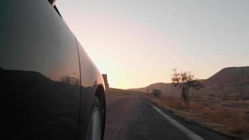 kantel naar beneden lage hoek bandenweergave wiel draaien in slow motion met schilderachtige natuur zonsopgang boven de horizon achtergrond video