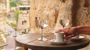 Goreme, Turkey, 2021 - Female hand takes white cup of turkish coffee in traditional cave cafe in Cappadocia video