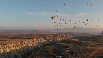 Flygfoto natursköna Kappadokiens dalar panorama med luftballonger i majestätisk blå himmel vid soluppgången video