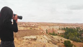 mujer fotógrafa turística tomando fotografías del valle con dslr fotografiando el paisaje escénico vista de fondo de la naturaleza disfrutando de la aventura de viajes de vacaciones video