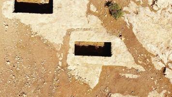 Aerial reveal view rock-cut tombs in historical ancient city Dara site in Mardin, Turkey . Mesopotamia culture .Roman empire