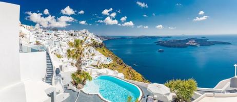 Sunny in Oia caldera panorama on Santorini island, Greece. Famous travel summer vacation destination. Swimming pool, white blue architecture, sunlight summer vibe. Inspirational panoramic landscape photo