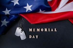 concepto del día conmemorativo. bandera americana y etiquetas de perro militar sobre fondo negro foto
