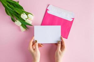 Woman holds greeting card in her hands. photo