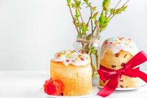 Delicious Easter cakes decorated with ribbon and flowers on white background. photo