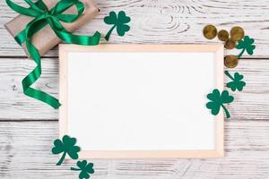 Clover shamrock, gold coins and a gift with a green ribbon on a white background photo