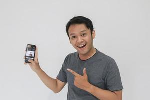Wow face and feeling happy of Young Asian man in grey t-shirt get surprised on the smartphone. photo