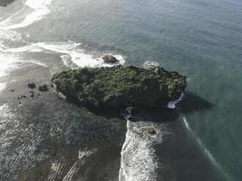 Aerial view of Beautiful beach with small island in the beach in Gunung Kidul, Indonesia in daylight. photo