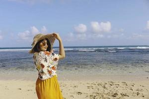 Portrait of happy smiling Asian woman on the beach wear hat photo