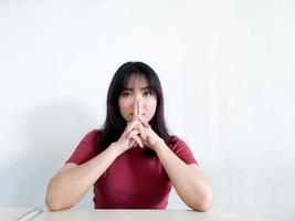 hermosa chica asiática con mirada afilada y expresión de cara seria con la mano en la cabeza foto