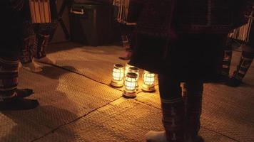 inheemse podiumkunsten aan toeristen. 's nachts zwak licht dansen akha bergstammen, gekleed in traditionele kostuums en prachtige ornamenten, ritmisch rond lantaarns, benen en voeten samen. video