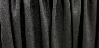 black satin fabric. black the cloth flutters. Waves of canvas Background photo