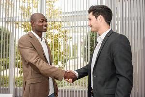 Black businessman shaking hands with a caucasian one photo