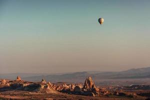 Hot air balloon flying over rock landscape at Cappadocia Turkey. photo