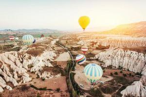 Hot air balloon flying over rock landscape at Turkey. Cappadocia photo