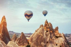 Hot air balloon flying over rock landscape at Turkey. Cappadocia photo