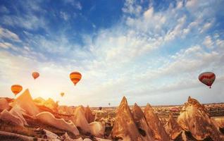 Hot air balloon flying over rock landscape at Turkey. Cappadocia photo