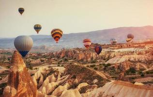 Hot air balloon flying over rock landscape at Turkey. Cappadocia photo