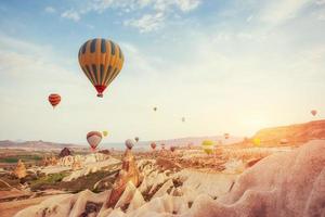 Hot air balloon flying over rock landscape at Turkey. Cappadocia photo