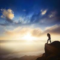 Nature photographer with digital camera on top of the mountain. photo