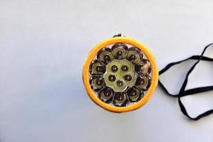 Yellow LED flashlight on white background photo