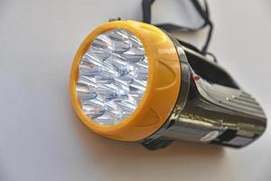 Yellow LED flashlight on white background photo