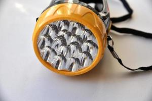 Yellow LED flashlight on white background photo