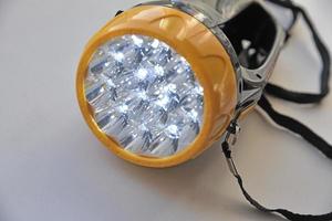 Yellow LED flashlight on white background photo