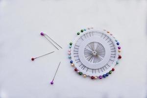 Multicolored needles and hairpins on a white background photo