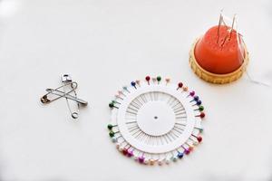 Multicolored needles and hairpins on a white background photo